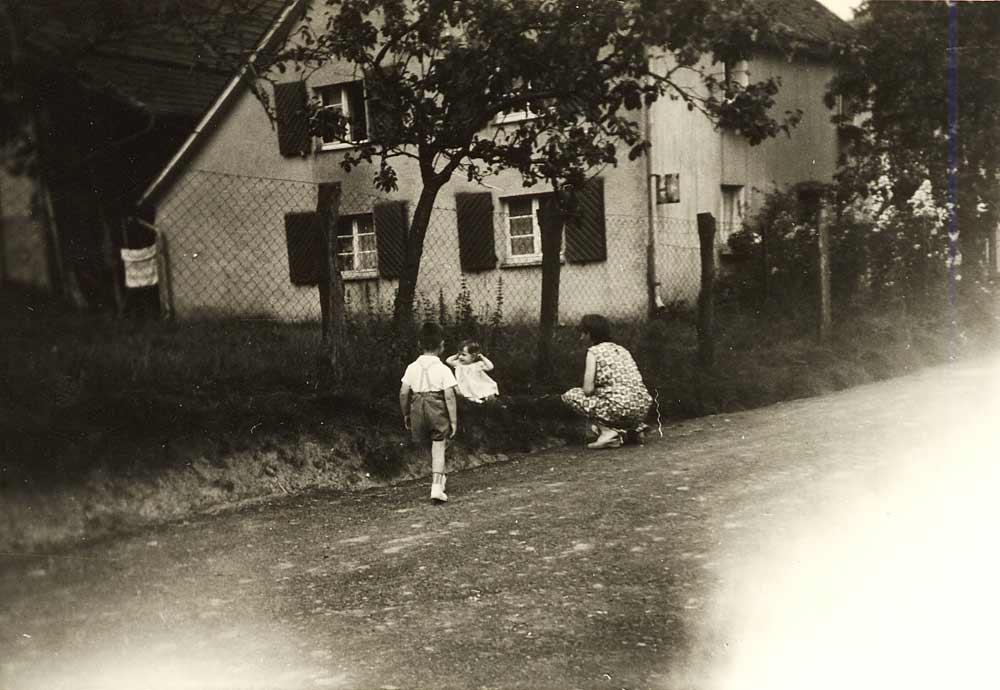 Maria Schenk mit ihren Kindern Karl-Joseph und Petra vor ihrem alten Haus